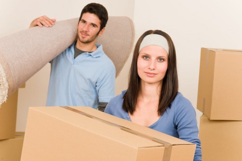 Professional movers carrying household items through a Kensington apartment building
